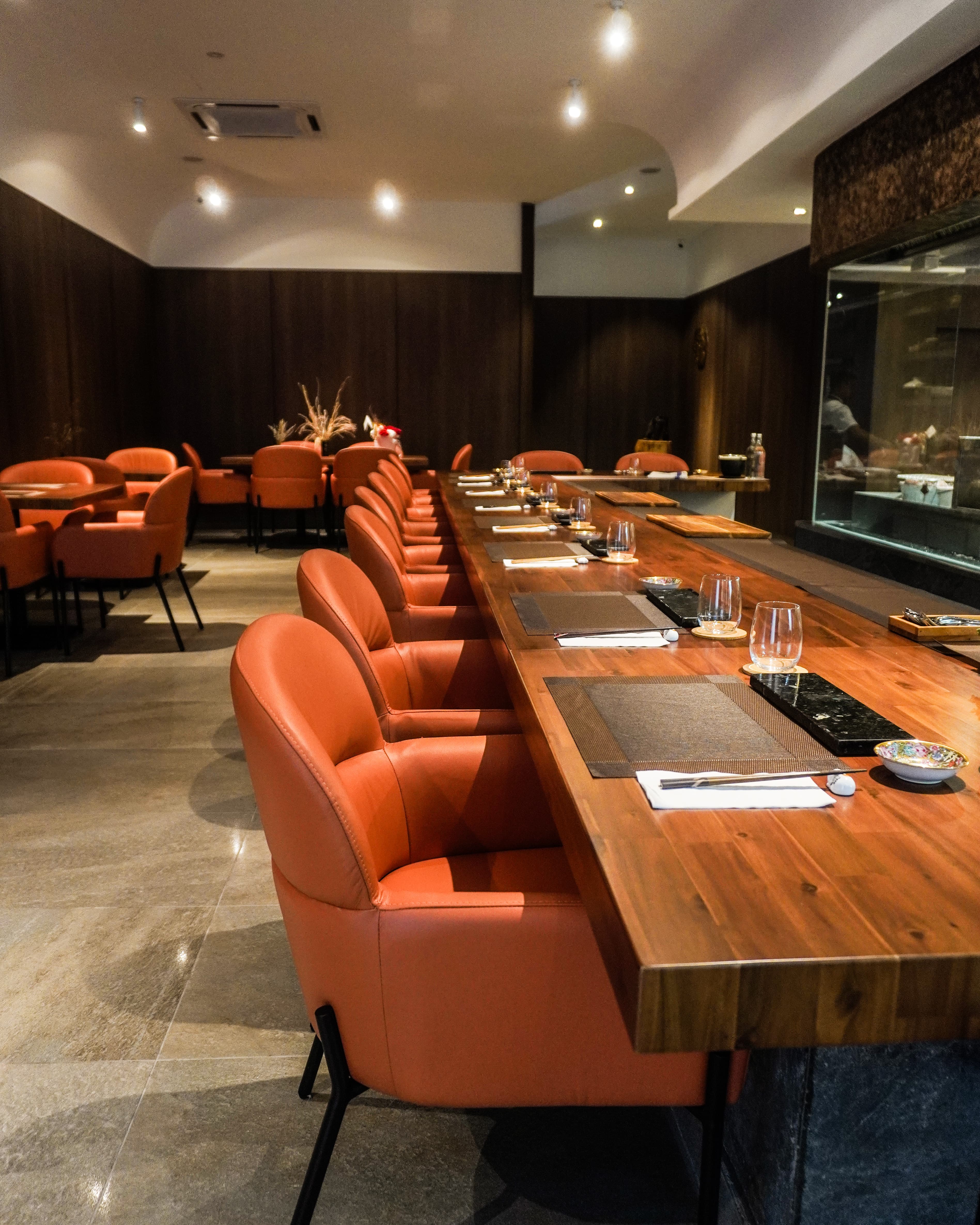 Carbon KL's main dining hall, counter seating along a timber bar facing the open kitchen