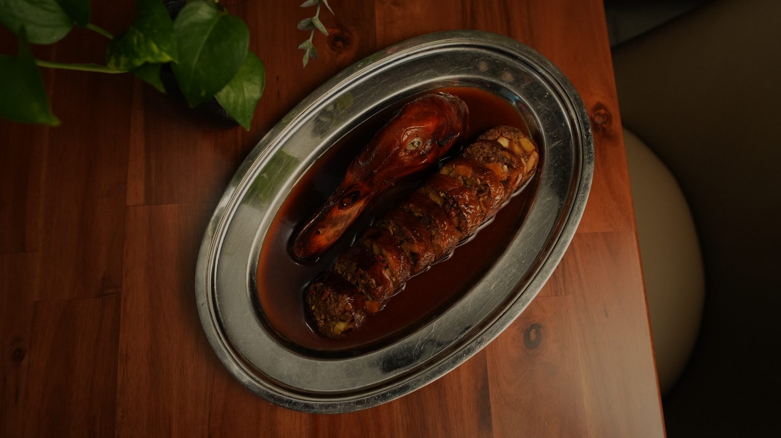 Duck neck sausage on an oval silver plate
